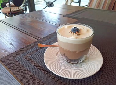 Üç Cafe ahşap masanın üstüne çikolata tatlı bırakır