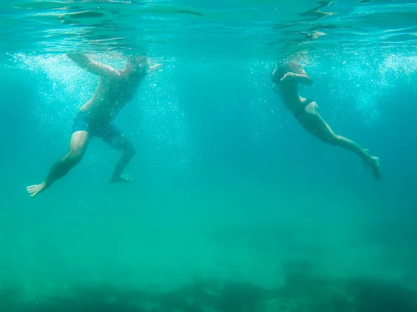年轻夫妇游泳在透明的海水在西班牙 — 图库照片
