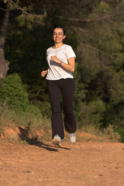 春で林道を走っているかなり若い女性 — ストック写真