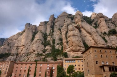 Montserrat ünlü Katolik Manastırı yuvarlak kayalar arka plan üzerinde görüntüleyin. Catalonia, İspanya.
