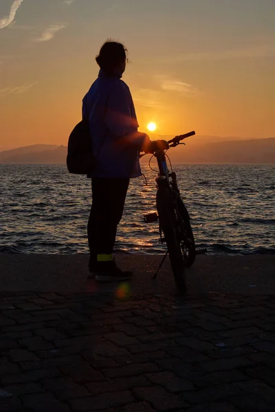 Pretty girl silhouette with bike in a sunset light — Stock Photo, Image