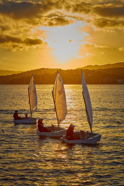 30º Trofeo Internacional de Vila de Palamós Optimist, 14ª Copa de Naciones. Veleros navegando hacia el puerto pequeño pueblo de Palamos en la Costa Brava española. 13. 02. España 2019 — Foto de Stock