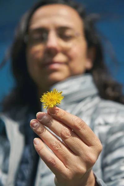 Pretty hispanic women with a yellow dandelion flower — Stock Photo, Image