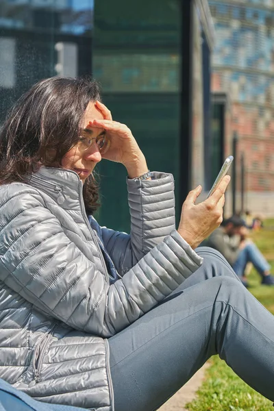 屋外で晴れた日に携帯を持つかわいい女性 — ストック写真