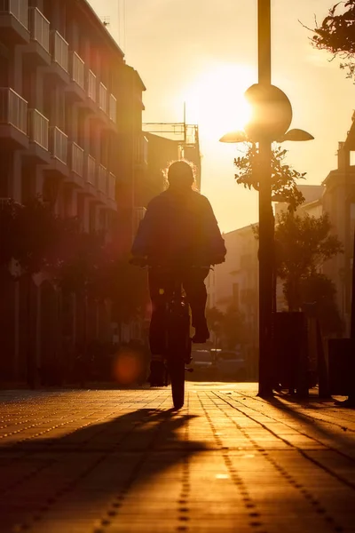 Девушка на велосипеде в красивом солнечном заднем свете — стоковое фото