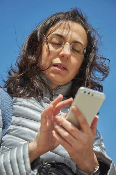 Красива жінка з мобільним телефоном в сонячний день на відкритому повітрі Ліцензійні Стокові Фото