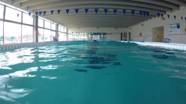 İspanya'nın Palamos kentinde yüzme havuzunda suda yüzen orta yaşlı beyaz adam  