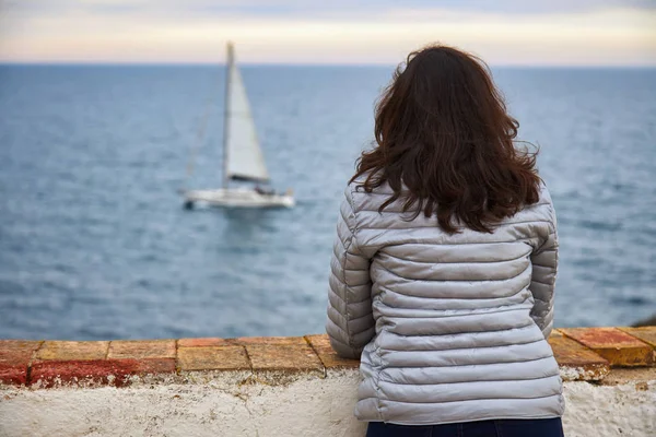 Mujer mirando mar infinito y velero — Foto de Stock