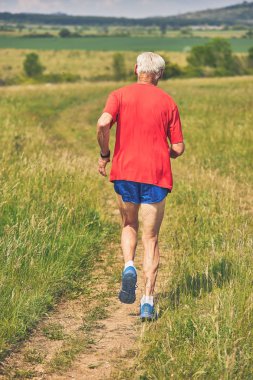 İlkbaharda çayırda koşan kıdemli koşucu