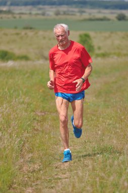 İlkbaharda çayırda koşan kıdemli koşucu