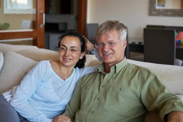 Casal de meia-idade tem uma olhando uma TV em casa — Fotografia de Stock