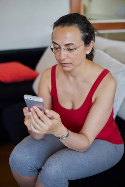 Jonge mooie vrouw thuis met smartphone mobiele — Stockfoto