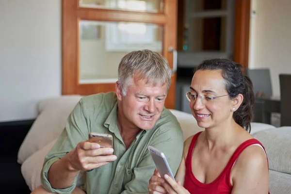 Casal de meia-idade procurando um telefone celular — Fotografia de Stock