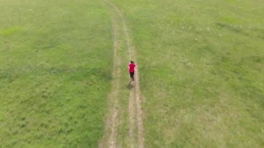 Sportif genç çayır üzerinde çalışan, hava görüntüleri