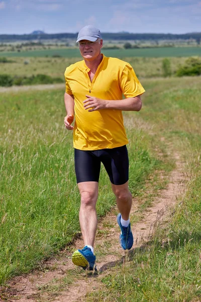 50-es caucasian man running on meadow — Stock Photo, Image