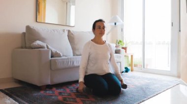 Güzel İspanyol kadın oturma odasında dambıllarıyla antrenman yapıyor.