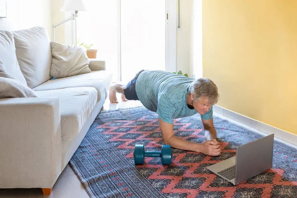 Blonde caucasian man practice online gymnastics at home in the living room