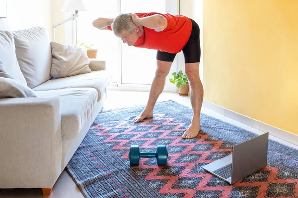 Blonde caucasian man practice online gymnastics at home in the living room