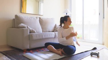 Evde yoga yapan genç bir kadının portresi..