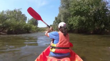 Genç İspanyol kadın güneşli bir yaz gününde Ter nehrinde kayak yapıyor. İspanya Katalonya 'sı
