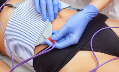 Prosedürü myostimulation oon göbek ve kalça güzellik salonu içinde bir kadın. Aşırı kilo azaltılması için vücut bakımı.