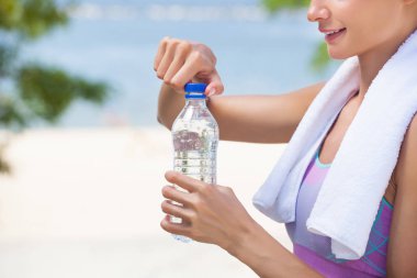 Bir sporcumuz bir spor eğitim oturumu sırasında onun elinde bir şişe su tutar.