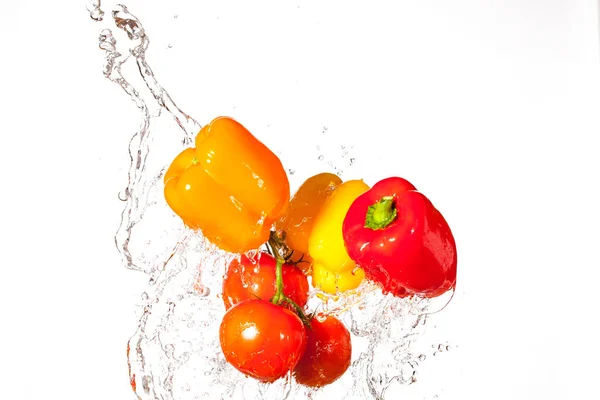 Fresh Peppers and Tomatoes Splashing Through Water
