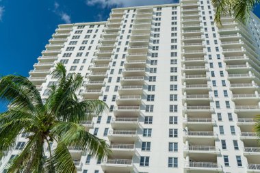 Miami, Florida yüksek katlı condominium ön planda palmiye ağaçları ile.
