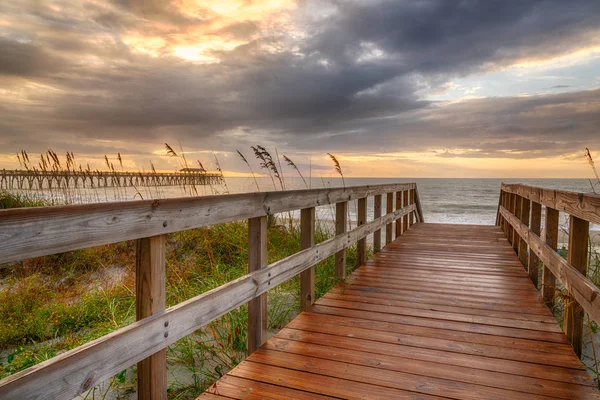 Strandpromenade, die bei Sonnenaufgang zum Strand führt — Stockfoto