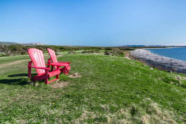 Zwei rote adirondack-Stühle entlang der Küste von Neufundland — Stockfoto