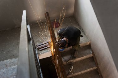 İnşaat alanında çalışıyor. Açı öğütücüsünde çalışıyor.