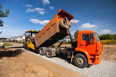 damperli kamyon yeni bir yol yapar asfalt paver, uykuya dalıyor