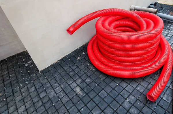 a crimped red plastic pipe rests on a metal base frame