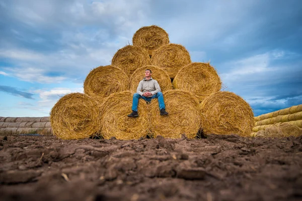 Hombre Sienta Rollos Amarillos Almacenados Heno Contra Cielo Azul —  Fotos de Stock