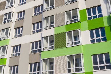 Yeşil-gri duvarlı yeni bir evin pencereleriyle ön cephenin bir parçası.