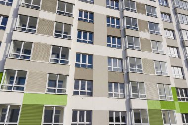 Yeşil-gri duvarlı yeni bir evin pencereleriyle ön cephenin bir parçası.