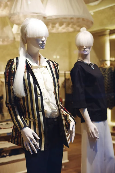 Mannequins standing in store window display of womens casual clothing shop in shopping mall