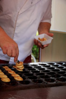 Sıcak döküm plaka, toz şeker ve tereyağı ile servis yapılan Poffertjes, Hollandalı küçük, tüylü krep,.
