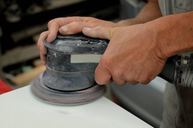 Bir araba parçası zımpara taşlama tezgahı ile adam araç tamir dükkanı,