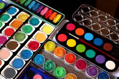 Stüdyoda farklı suluboya boya kutuları var.