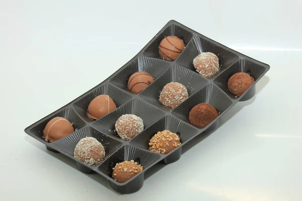 Various chocolates in a tray, bonbons with different topping and filling