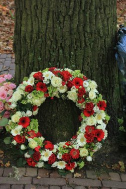 Mezarlıktaki bir ağacın yanında klasik Sempati Çelengi