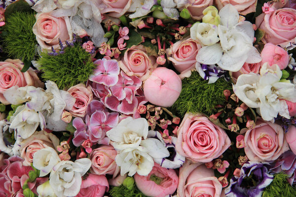 Wedding arrangement in various shades of pink and different sorts of flowers