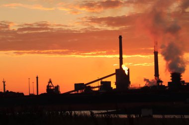 Gün batımında sanayi bölgesinin silüeti
