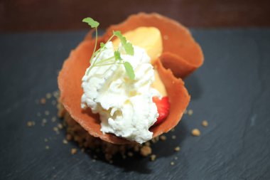 Küçük meyve tatlı gevrek bir tanımlama bilgisinde çırpılmış krema ve yeşil garnitür ile