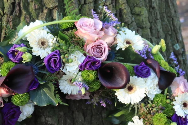 White and purple sympathy flowers in a funeral wreath