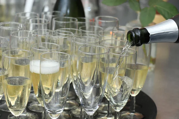 Pouring champagne in stylish glasses — Stock Photo, Image