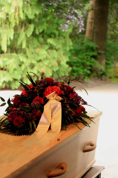 Un ataúd con un arreglo floral en una morgue — Foto de Stock
