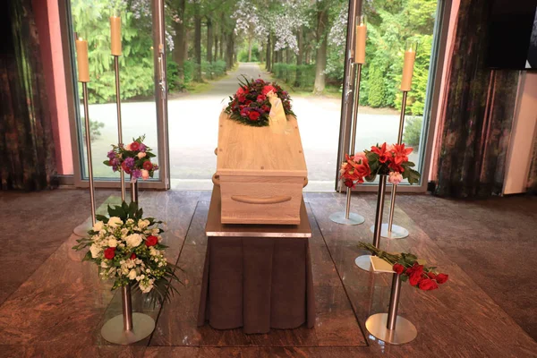 A coffin with a flower arrangement in a morgue — Stock Photo, Image