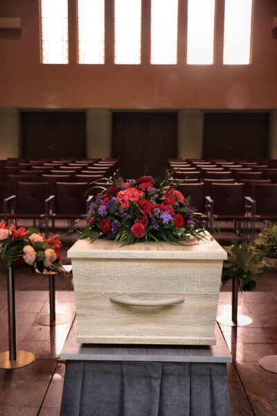 A coffin with a flower arrangement in a morgue